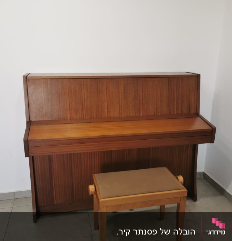 פסנתר עומד עם שרפרף עץ על רצפת אריחים